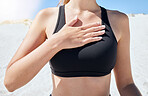 Hand, chest and breathing with a sports woman on the beach during summer for health or wellness. Yoga, nature and fitness with a female athlete by the ocean or sea for exercise and mindfulness