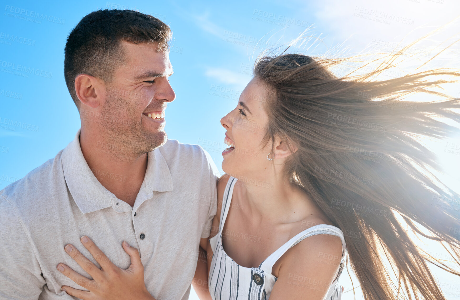 Buy stock photo Couple, love and hug together in summer for travel adventure vacation outdoors. Excited woman, happy man and funny comedy conversation, romance bonding and quality time or support in sunshine