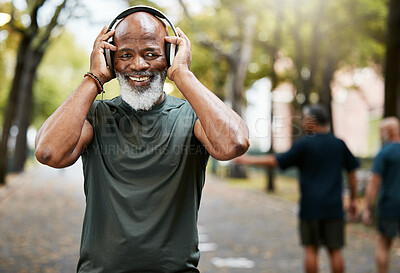 Buy stock photo Music, fitness and running with a senior black man in a park for cardio exercise or an endurance workout. Portrait, happy and health with a mature male runner outdoor for training or wellness