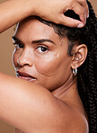 Portrait, beauty and black woman skincare, face and natural makeup cosmetics in brown studio background. Gen z model, foundation and facial cosmetics, healthy skin and promotion for facial wellness