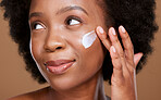 Black woman, face cream and beauty, sunscreen makeup product and luxury facial treatment on studio background. Young african model, body lotion and cosmetics for healthy skincare, wellness and shine 