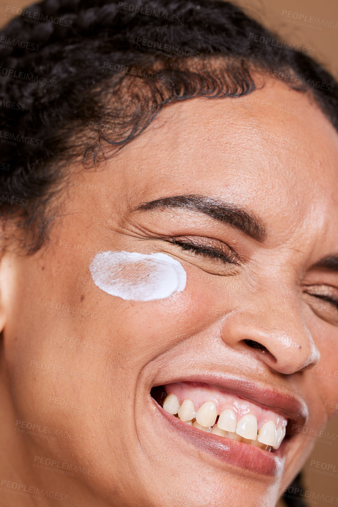 Buy stock photo Cream, skincare and face of a woman excited about a product for beauty against a brown studio background. Sunscreen, happy and girl model with a smile for facial creme, dermatology and zoom on glow