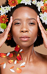 Flower, crown and portrait of woman in studio for beauty, skincare and nature product on brown background. Face, flower and black woman relax with glowing skin, facial and wellness floral aesthetic