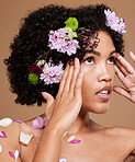 Flowers, skincare and woman in studio for beauty, skin and facial by nature, plant and product on brown background. Flower, crown and black woman and floral aesthetic for wellness, cosmetic and zen  