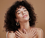 Woman, afro and relax in beauty for skincare, cosmetics or makeup against a brown studio background. Female holding body in satisfaction for healthy wellness, hygiene or luxury facial treatment