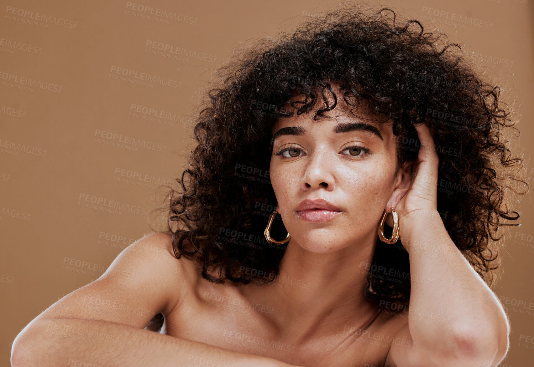 Buy stock photo Beauty, natural hair and skincare with woman, hair care and wellness cosmetics portrait against brown studio background. Healthy skin, makeup and glow with clean cosmetic mockup and curly hair.