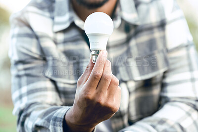 Buy stock photo Energy, nature and hand of man with light bulb for conservation innovation, engineering or creativity. Eco, bulb and idea of outdoor person for sustainability, green energy and development.

