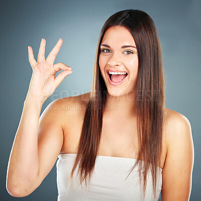 Buy stock photo Beauty, skincare and ok sign with a woman in studio for cosmetics, makeup and hair care on a blue background. Portrait of aesthetic model excited about glow, dermatology and self care routine