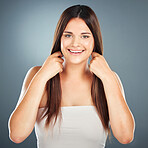 Hair, portrait and brunette woman for haircare, beauty and cosmetology on a grey studio background. Glamour, hair care and healthy hair with a hairstyle for a happy female with long hair treatment