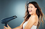 Woman, hair and hair dryer with smile in studio for self care, hair care or cosmetics by blue background. Girl, happy and excited with hairdryer for wellness, cosmetic care and beauty by backdrop