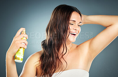 Buy stock photo Beauty, hair care and woman in studio with cosmetic holding hair spray for shine and growth on a blue background for self care. Aesthetic model happy about luxury product for health and wellness