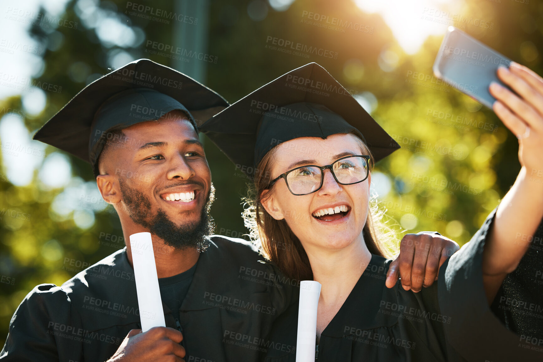 Buy stock photo Selfie, college graduation and students in university celebrate academic success with a happy smile, black gown and graduation cap. Education, graduate certificate and friends with diploma in hands