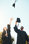 University, graduation and students with graduation cap in air for celebration, happiness and joy. College, education and man and woman throw hats after achievement of degree, diploma and certificate