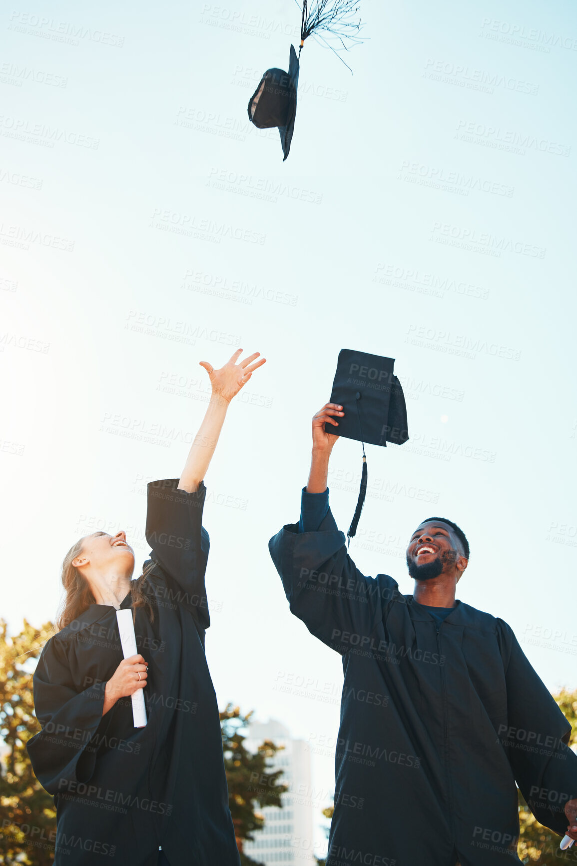 Buy stock photo University, graduation and students with graduation cap in air for celebration, happiness and joy. College, education and man and woman throw hats after achievement of degree, diploma and certificate
