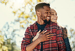 Diversity, love and couple hug in nature for relax summer holiday, outdoor freedom and happy quality time. African man, woman eyes closed and happiness together, hugging and loving in nature sunshine