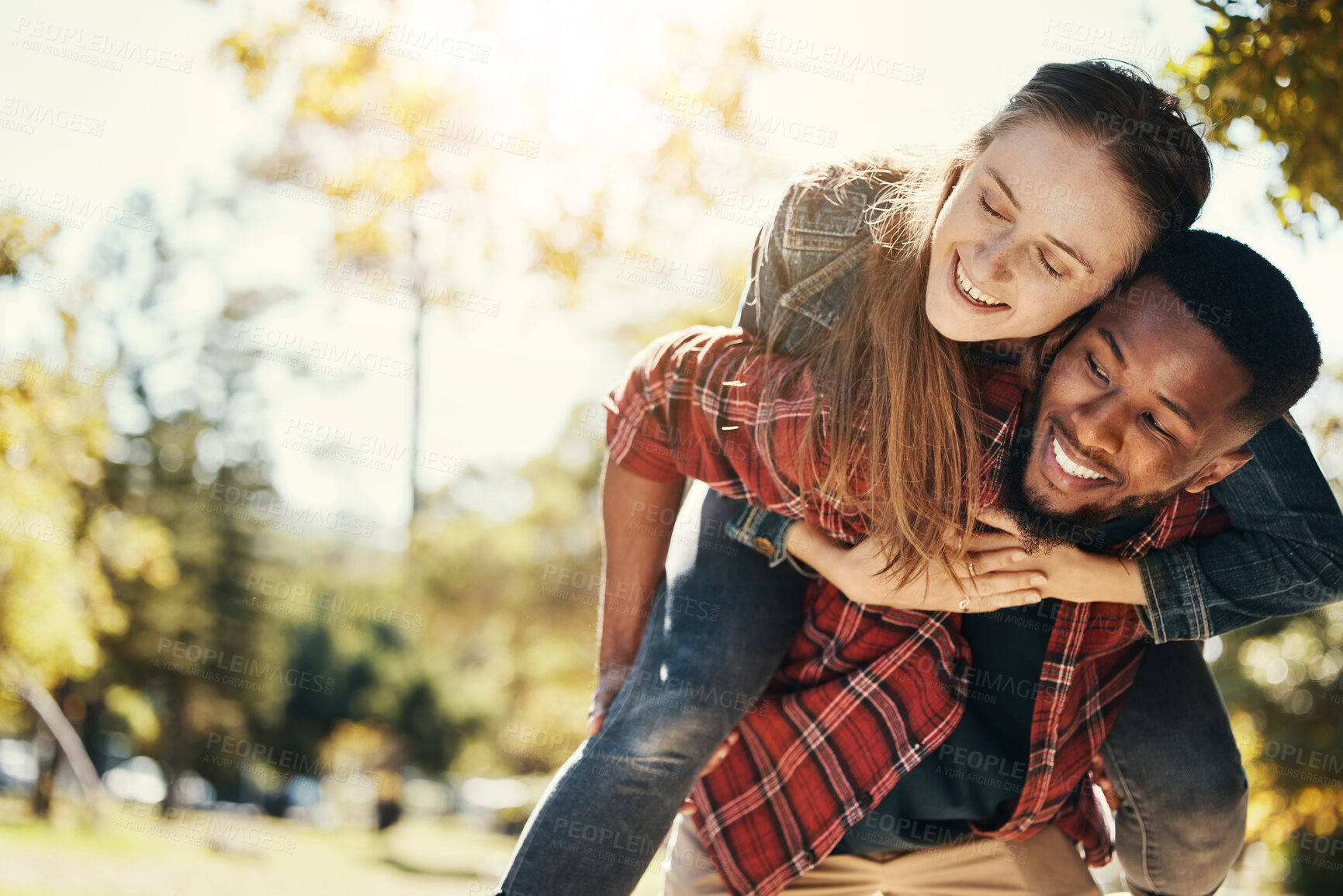 Buy stock photo Love, care and interracial couple with piggyback in a park for support, adventure and happy with mockup and bokeh. Hug, smile and black man and woman on an outdoor date in nature with space in summer