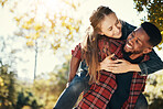 Love, couple and piggy back in nature on vacation, holiday or date outdoors. Romance, diversity and happy man carrying woman on shoulders, having fun or enjoying quality time together at park outside
