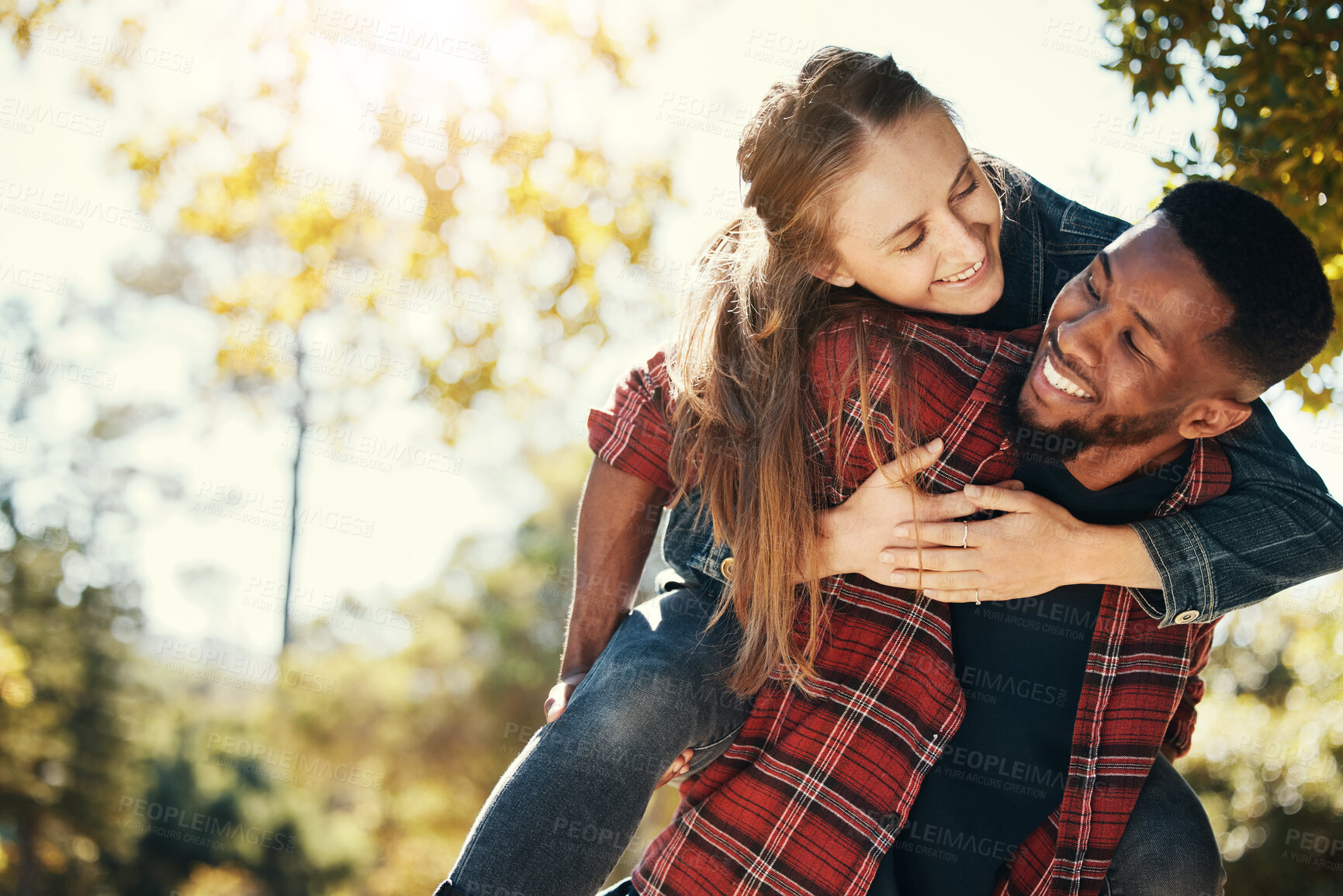 Buy stock photo Love, couple and piggy back in nature on vacation, holiday or date outdoors. Romance, diversity and happy man carrying woman on shoulders, having fun or enjoying quality time together at park outside