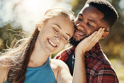 Buy stock photo Park, love and interracial young couple enjoying weekend, holiday and summer vacation together. Bonding, affection and happy black man and white woman embrace, hugging and smiling outdoors in nature