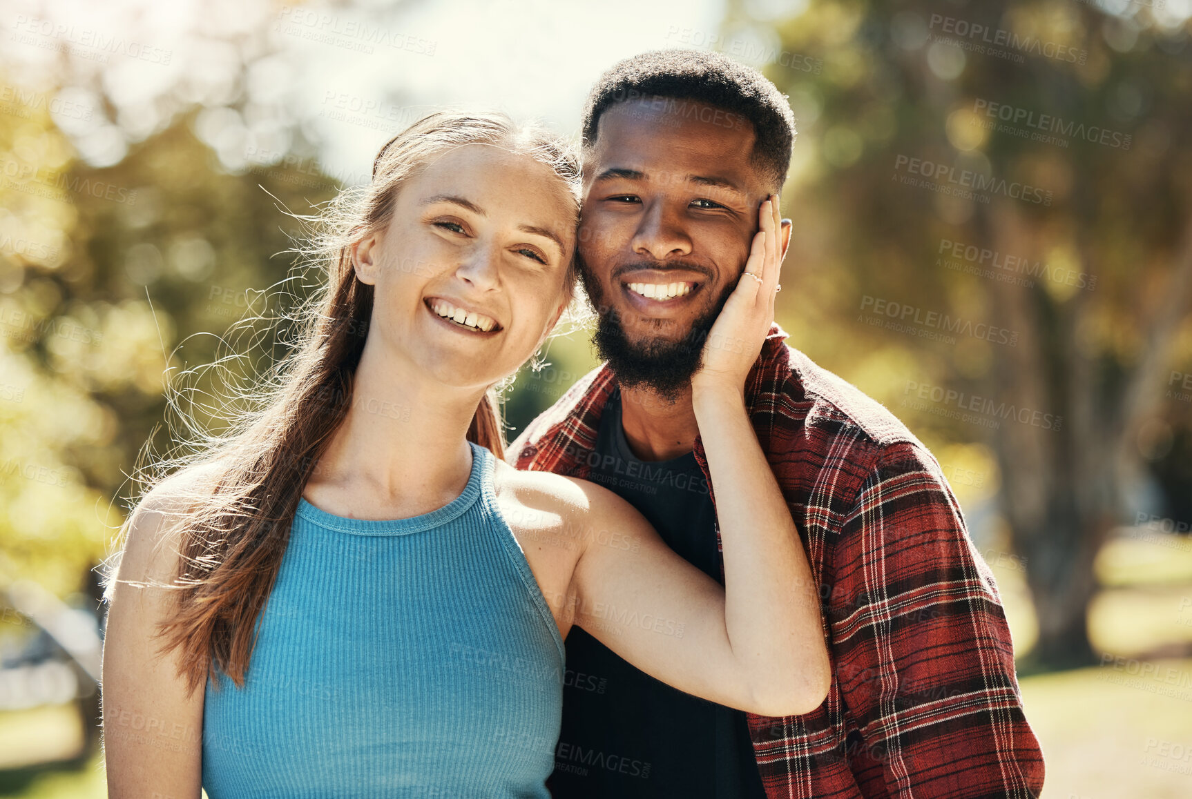 Buy stock photo Portrait of interracial couple, young people and relax in park, sunshine and summer for love, care or quality time together. Happy man, smile woman and diversity date in nature, outdoor and happiness