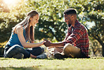 Couple, park and love while outdoor in nature for freedom, support and trust in marriage partner while on grass feeling happy. Interracial man and woman together on lawn for a date and quality time