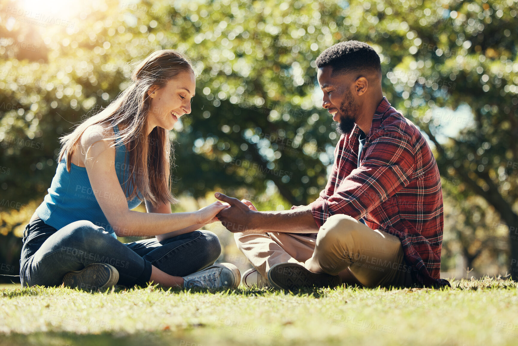 Buy stock photo Couple, park and love while outdoor in nature for freedom, support and trust in marriage partner while on grass feeling happy. Interracial man and woman together on lawn for a date and quality time