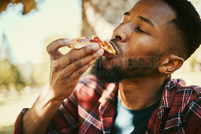 Buy stock photo Fast food, hungry and black man eating pizza for  delicious and yummy lunch break in park. Gen z, food and hunger of young person enjoying carbs pizza slice meal with satisfied face.


