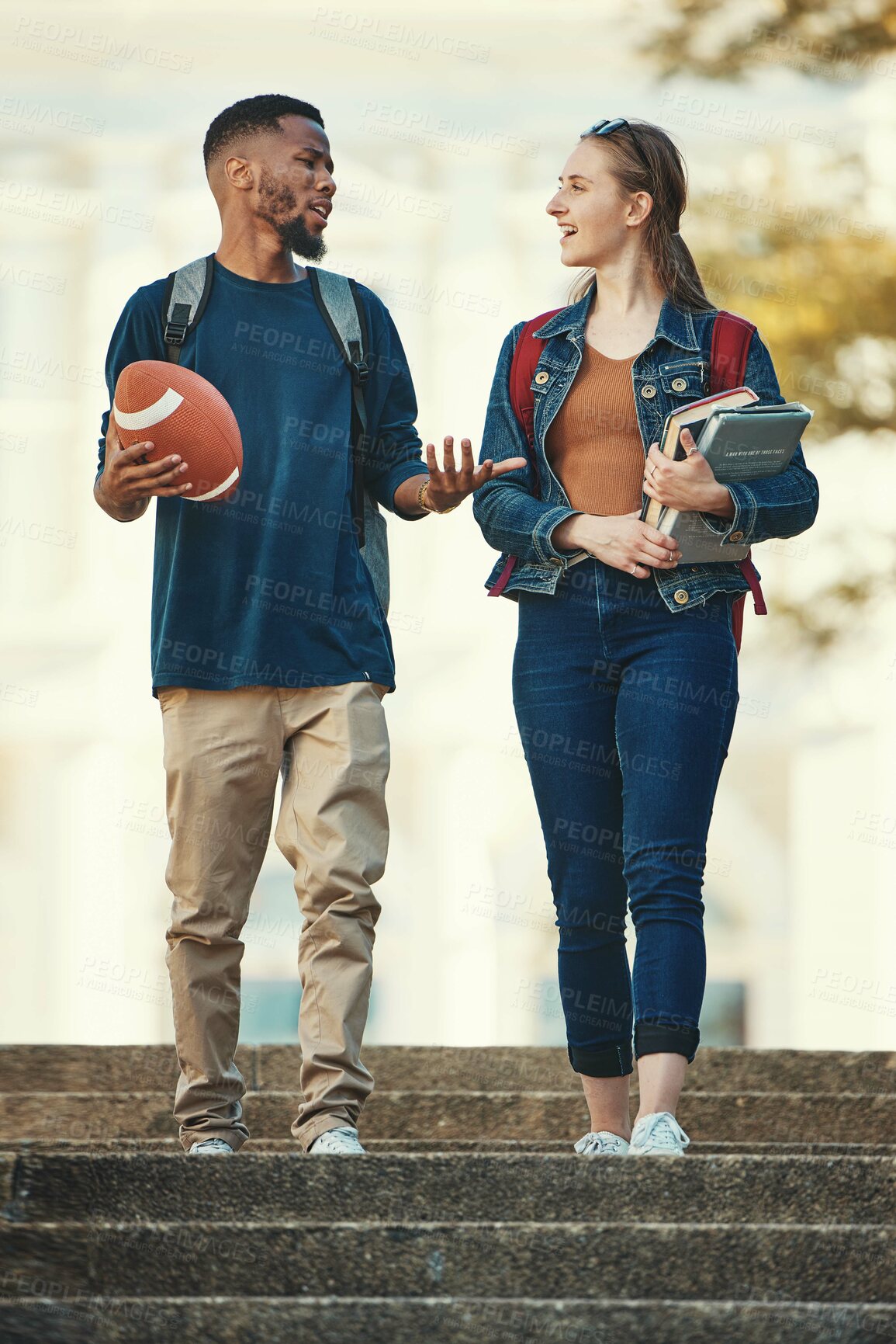 Buy stock photo Students, couple and conversation in walk on stairs at college, university or school books. Friends, diversity and campus for learning, education or study in discussion, together and walking to class