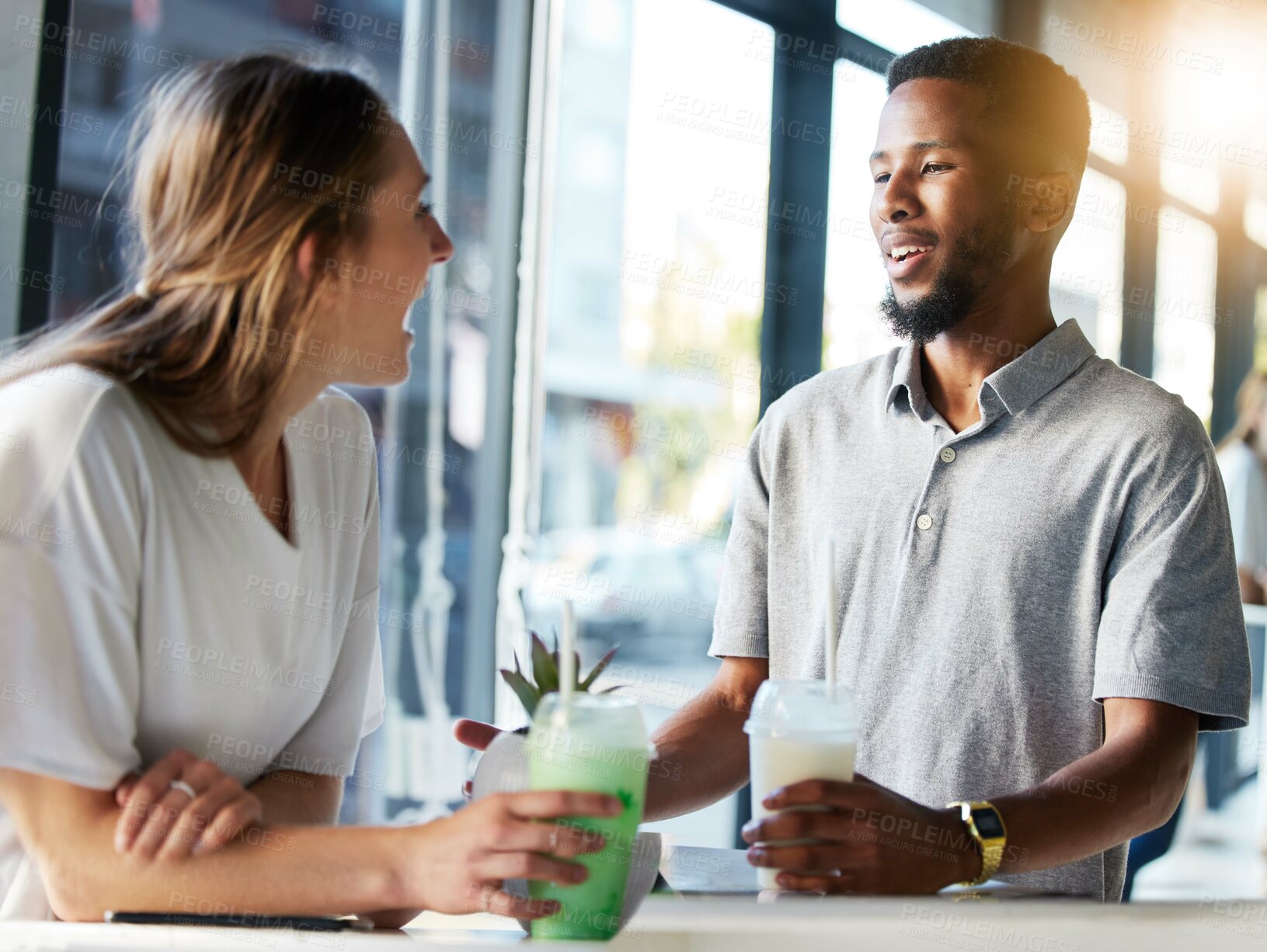 Buy stock photo Restaurant, date and couple drinking milkshake while talking, bonding and laughing together. Happy, love and interracial man and woman in conversation while enjoying smoothie at a cafe in the city.