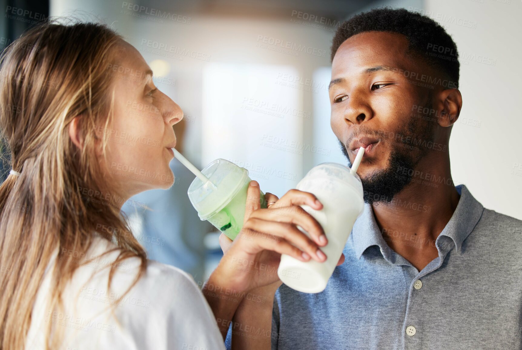 Buy stock photo Restaurant, date and couple drinking a milkshake together while at a romantic summer adventure. Happy, love and interracial man and woman enjoying a smoothie at a cafe or coffee shop in the city.