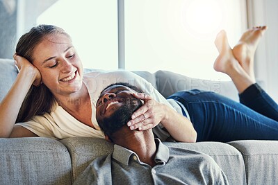 Buy stock photo Affection, happy and interracial couple with love, care and smile in the living room of their house. Relax, peace and woman embracing face of a man with happiness and calm on the sofa of an apartment