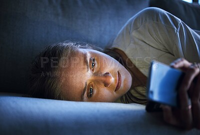 Buy stock photo Phone, night and sad woman relaxing on sofa in living room scrolling on social media after a break up. Depression, upset and girl on couch in lounge reading student loan or debt emails on smartphone.