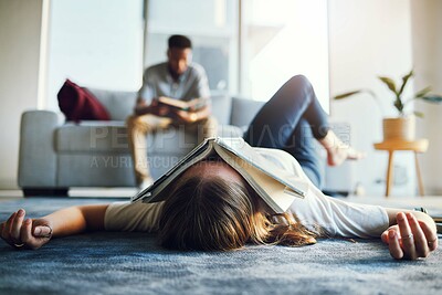 Buy stock photo Burnout, tired and student with book on face laying on floor after studying, reading and working on project. Education, university and woman exhausted, stressed and sad from college in living room