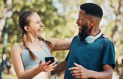 Buy stock photo Headphones, fitness and couple with phone in nature on break after workout, running or training. Sports, diversity and man and woman streaming music, radio or podcast outdoors on 5g mobile smartphone