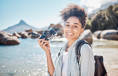 Buy stock photo Travel, beach and camera with a black woman tourist taking a photograph by the sea or ocean water in summer. Nature, portrait or photographer with a female outdoor on holiday or vacation by the coast