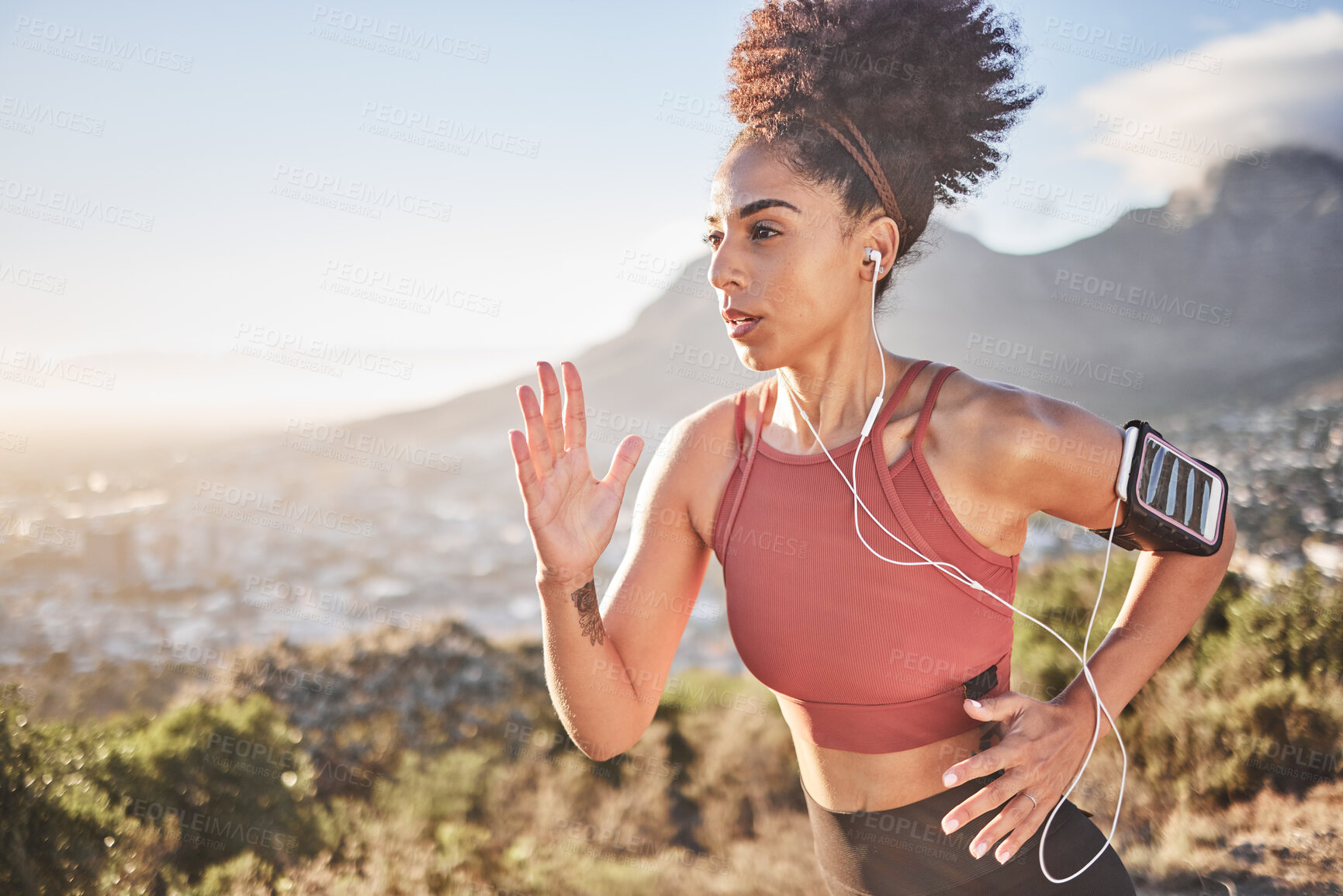 Buy stock photo Earphones, fitness and black woman running in nature outdoors streaming music, radio or podcast for motivation. Health, wellness and female runner listening to audio, song and training sound track.