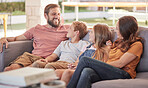 Happy family, sofa and relax together, laugh and funny joke with smile, happiness and sitting in home. Father, mother and young kids on couch with bonding, comic and love in lounge at holiday house