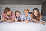 Happy, relax and portrait of a family on a bed for love, peace and calm in their house together. Smile, happiness and comfort for children with their mother and father in the bedroom of their home