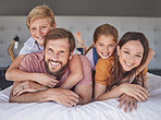 Happy, relax and portrait of family in bedroom for bonding, support and smile together. Affection, playful and weekend with parents and children at home for natural, rest and embrace in the morning