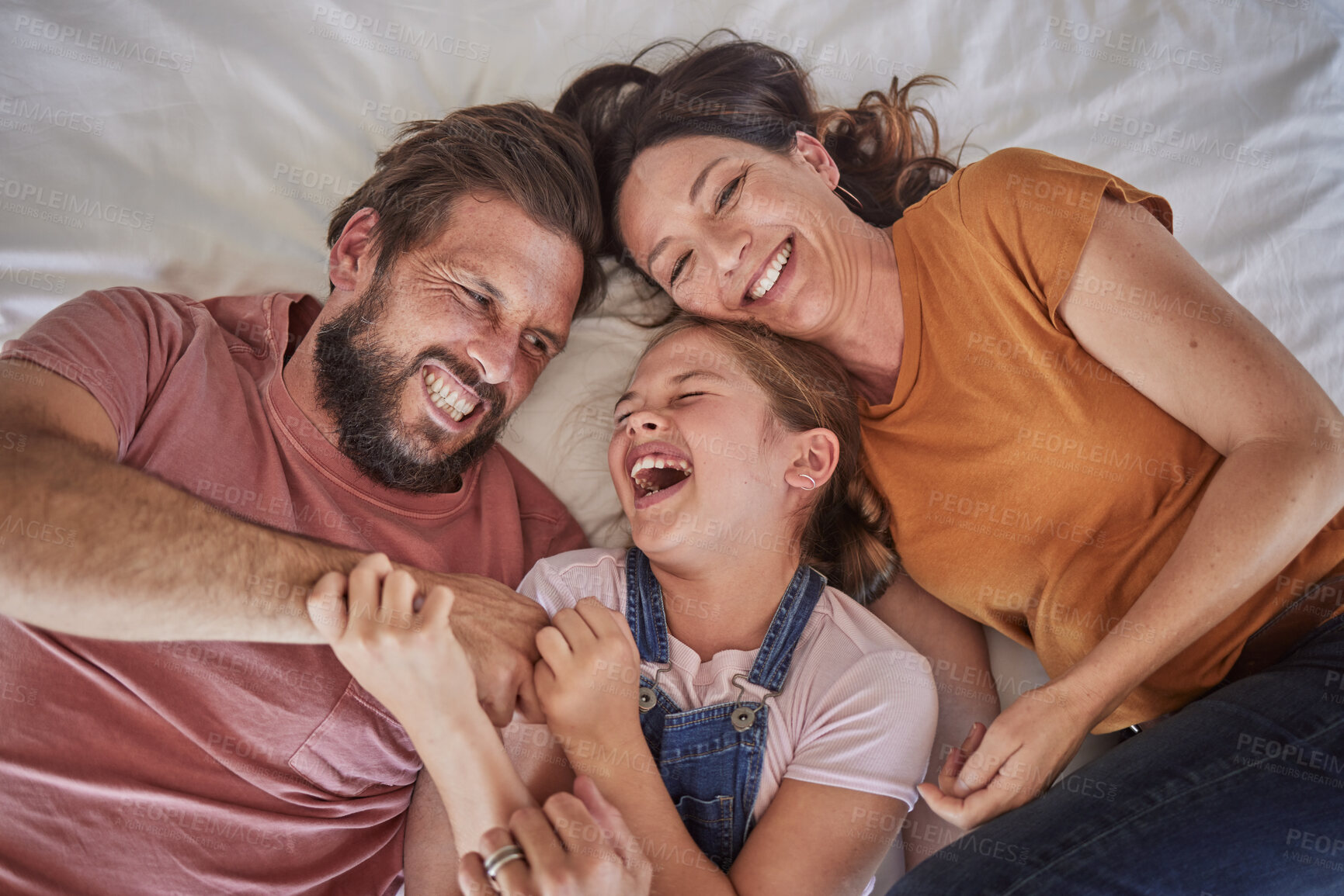 Buy stock photo Family, bed and child with tickle, happy or comic play for quality time, bonding or home together. Above, parents and girl with happiness, laugh or crazy with love, mom and dad in happy family house