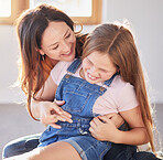 Happy, love and mother bonding with her child while playing, laughing and relaxing together at their home. Happiness, smile and woman being playful with her girl kid in their modern house in Canada.