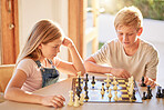 Children, chess and board game while thinking of move with knowledge, strategy and  planning to win for development and growth at home. Kids, siblings or boy and girl together for learning games