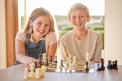 Buy stock photo Kids, chess and board game in portrait in house for learning, strategy and happy development together. Children, girl and brother with smile, happiness and family games at table in home living room