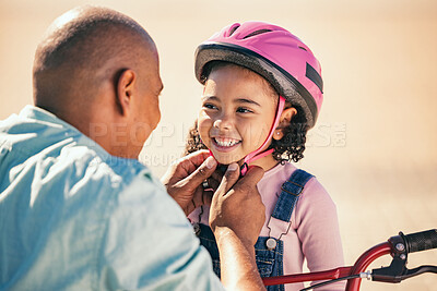 Buy stock photo Bike safety, kid and helmet of a girl with father ready for cycling learning outdoor with a smile. Dad with happy kid putting on safe gear for a bicycle teaching lesson with happiness and care