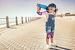 Portrait, skateboard and child in city, street or outdoors promenade ready for skating practice. Skateboarding sports, exercise and young girl preparing for training or fitness workout at seashore.
