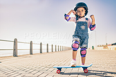 Buy stock photo Children, skate and strong with a girl on her skateboard for fun on the beach promenade alone during summer. Muscle, bicep and helmet with a female child skating outside on a sidewalk with knee pads