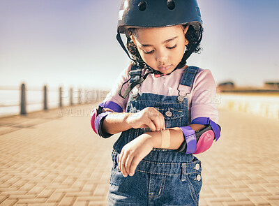 Buy stock photo Cycling injury, arm bandage and child in street with bruise after fall or accident. First aid, bandaid and hurt city girl with safety helmet after playing, sports or fitness exercise alone on road.