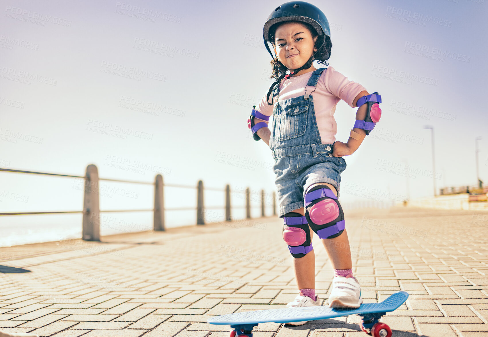Buy stock photo Skateboard, cool and girl with power in the city while riding during summer. Action, urban and portrait of a strong young child learning, playing and skateboarding in the street for happiness