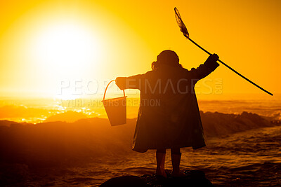 Silhouette, sunset and child at beach with toys for travel, holiday and playing by water in Australia. Earth day, ocean and back of girl kid in the dark during sunrise to play and relax on vacation