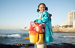 Ocean, fishing and portrait of girl with smile sitting on dock, fun and happy time at beach holiday weekend. Nature, blue sky and waves, child at the sea with fishing net ready to catch fish in water